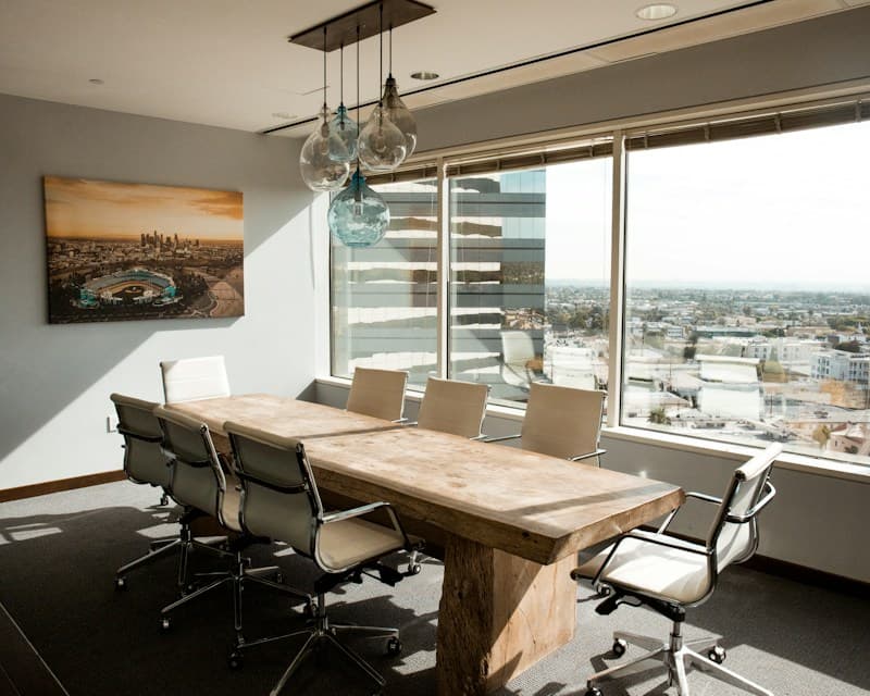 Clean conference room table with whiteboard and meeting supplies